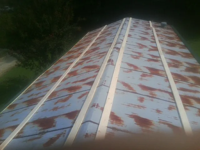 Rusted metal roof panels with new wood purlins before replacement — Storm Damage Roof Repair in Manquin by Roofing Brothers