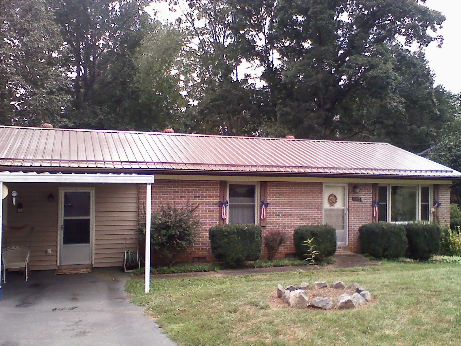 Bronze metal roof and carport on a brick ranch home — Roof Repair work by our crew in Manquin